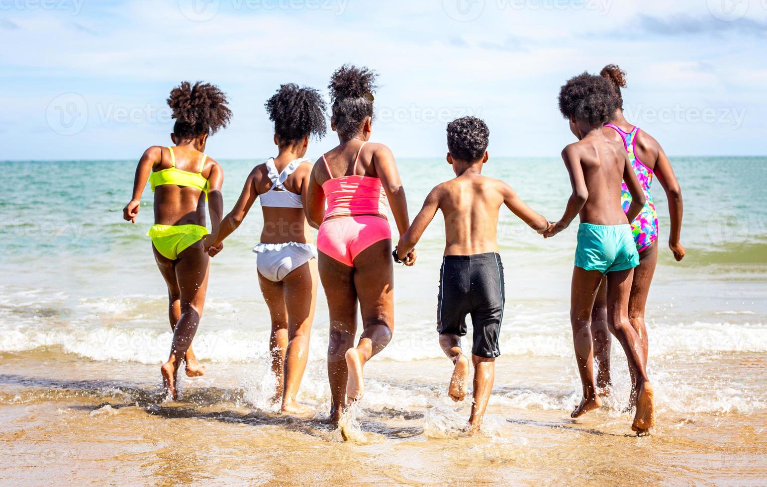 Kids playing running on sand at the beach photo