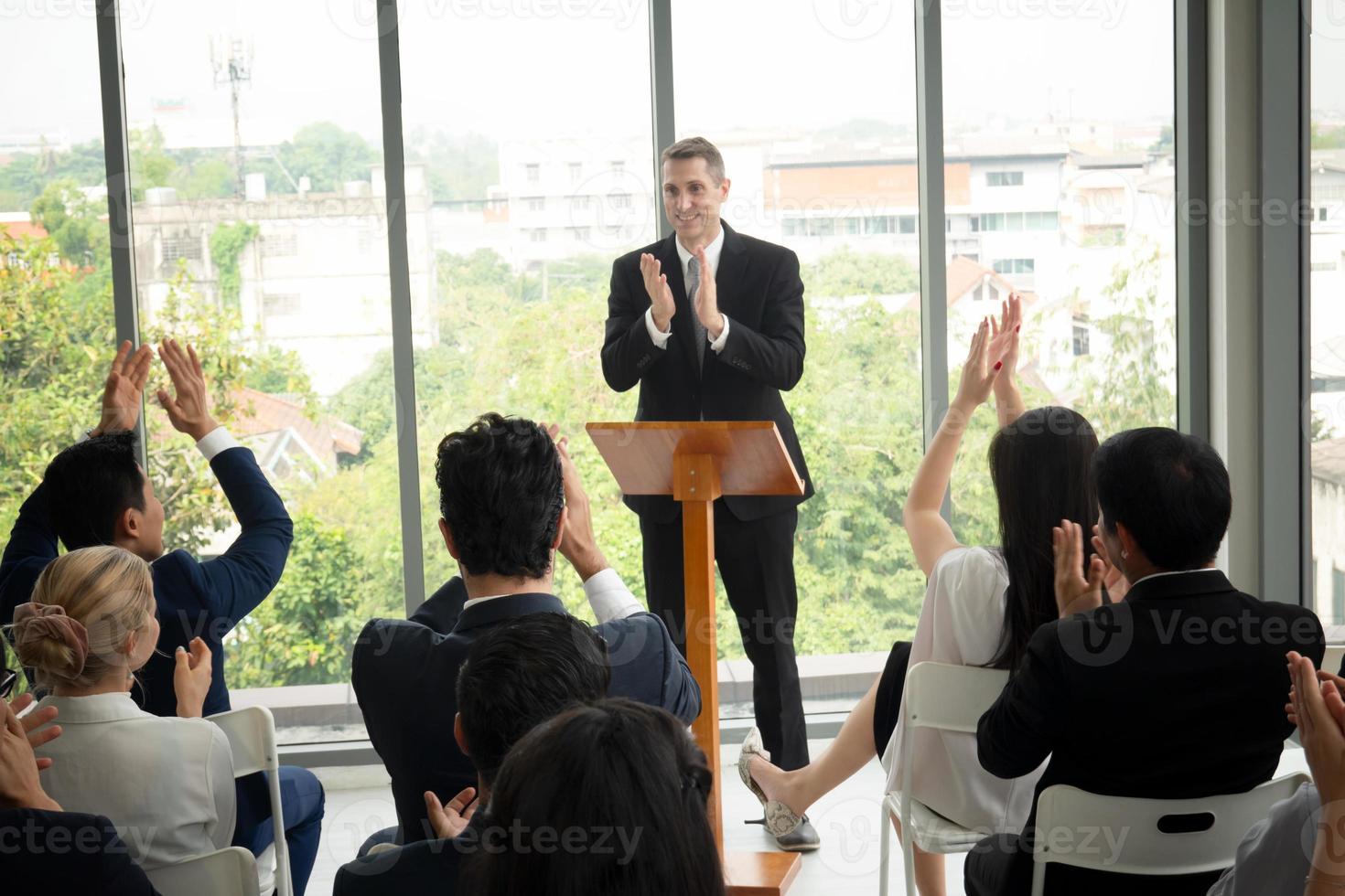 Group of people listening to experienced business professional helping them work out new corporate strategy. photo