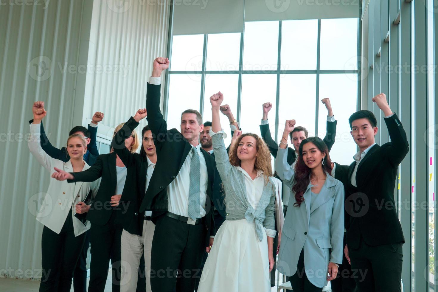 Successful business people standing together widen out showing strong relationship of worker community. A team of businessman and businesswoman expressing a strong group teamwork at the modern office. photo