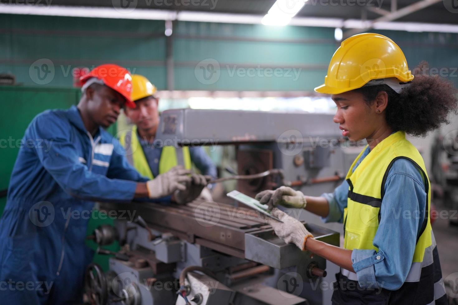 Maintenance Engineers is working in front of the automated CNC machinery repair on a maintenance checklist at the production line. photo