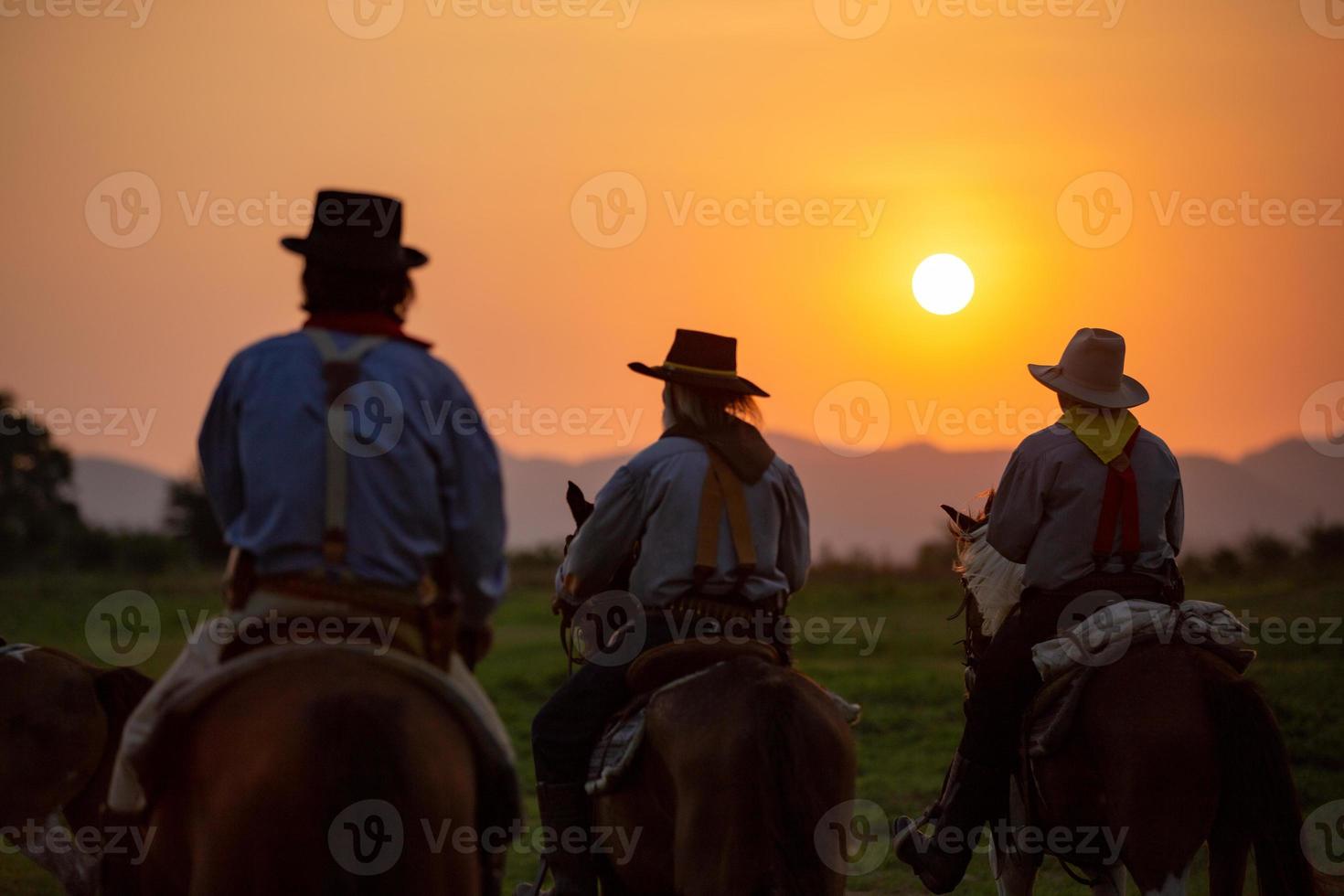 Silhouette Cowboy on horseback against a beautiful sunset, cowboy and horse at first light, mountain, river and lifestyle with natural light background photo