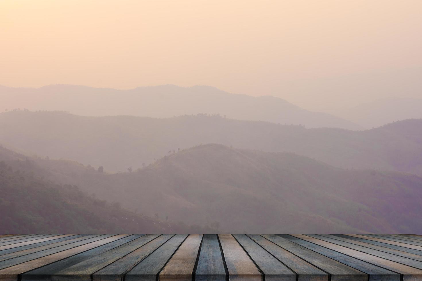 mesa de madera y desenfoque de belleza, cielo al atardecer y montañas como fondo. foto