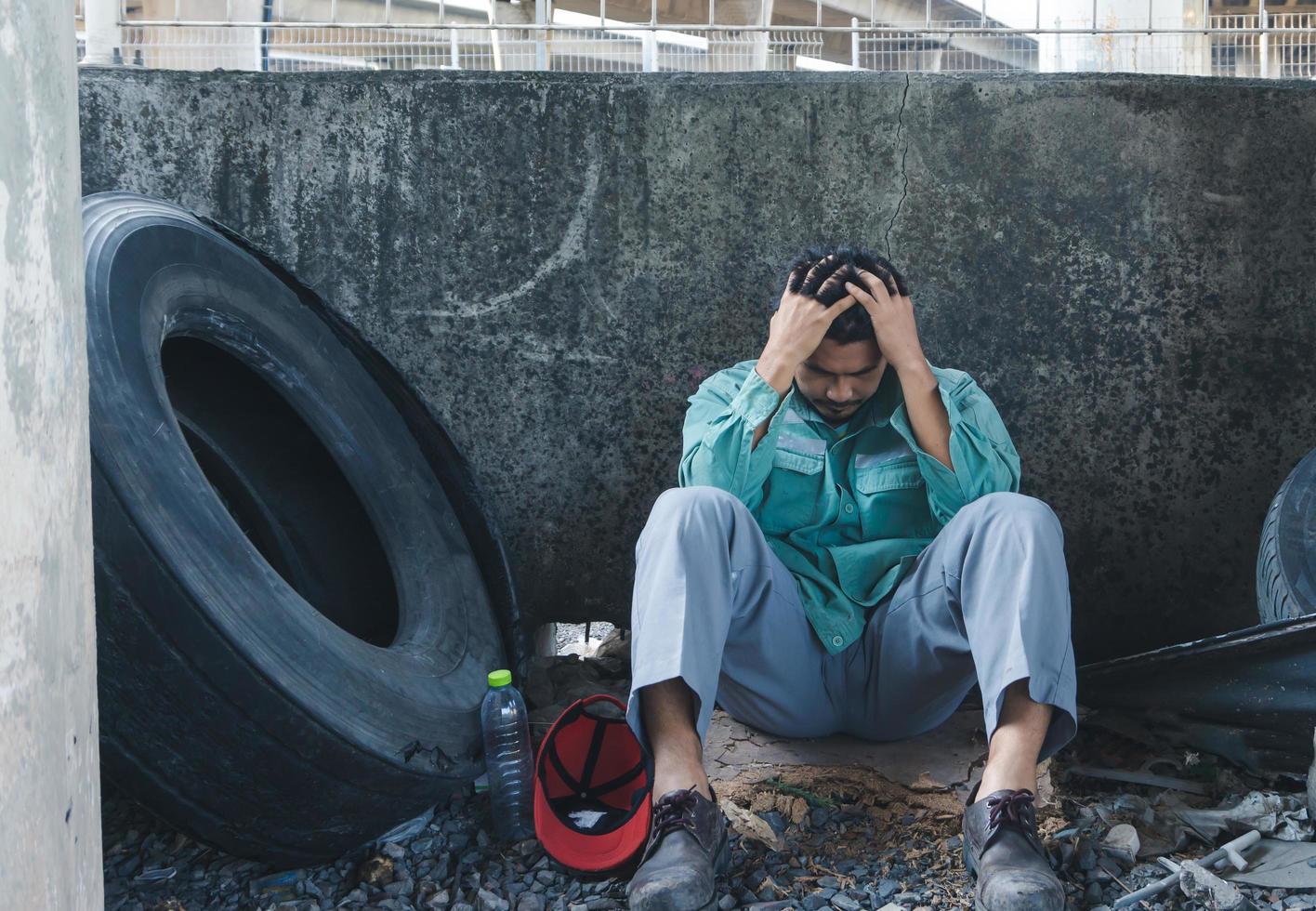 A man sitting by a wall photo