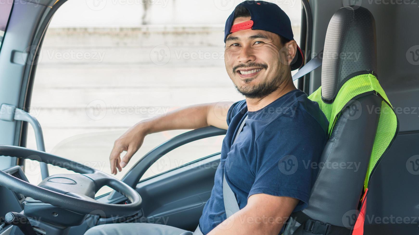 The Asian truck driver  man smiling happily inside the front of the truck. He is the owner of a shipping business that starts a new business and is growing. photo