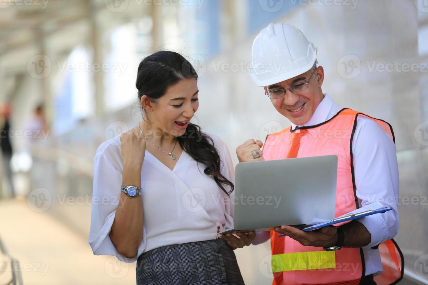 The engineer and business woman checking on clipboard at construction site building. The concept of engineering, construction, city life and future. photo