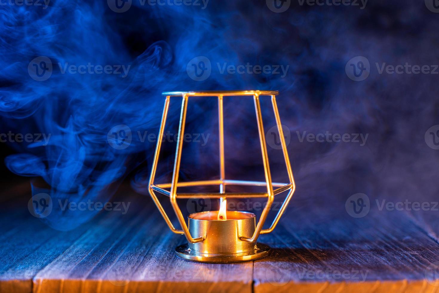 concepto de halloween, linterna de calabaza naranja y velas en una mesa de madera oscura con humo azul-naranja alrededor del fondo, truco o trato, cerrar foto