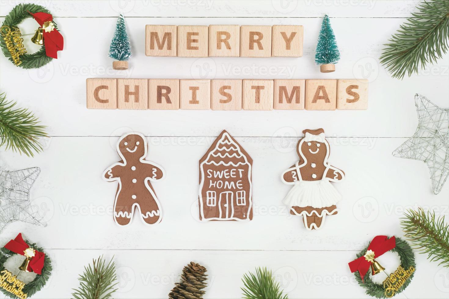 objetos de decoración de composición de concepto de navidad, corona de rama de abeto, galleta de hombre de pan de jengibre aislada en una mesa de madera blanca, vista superior, capa plana foto