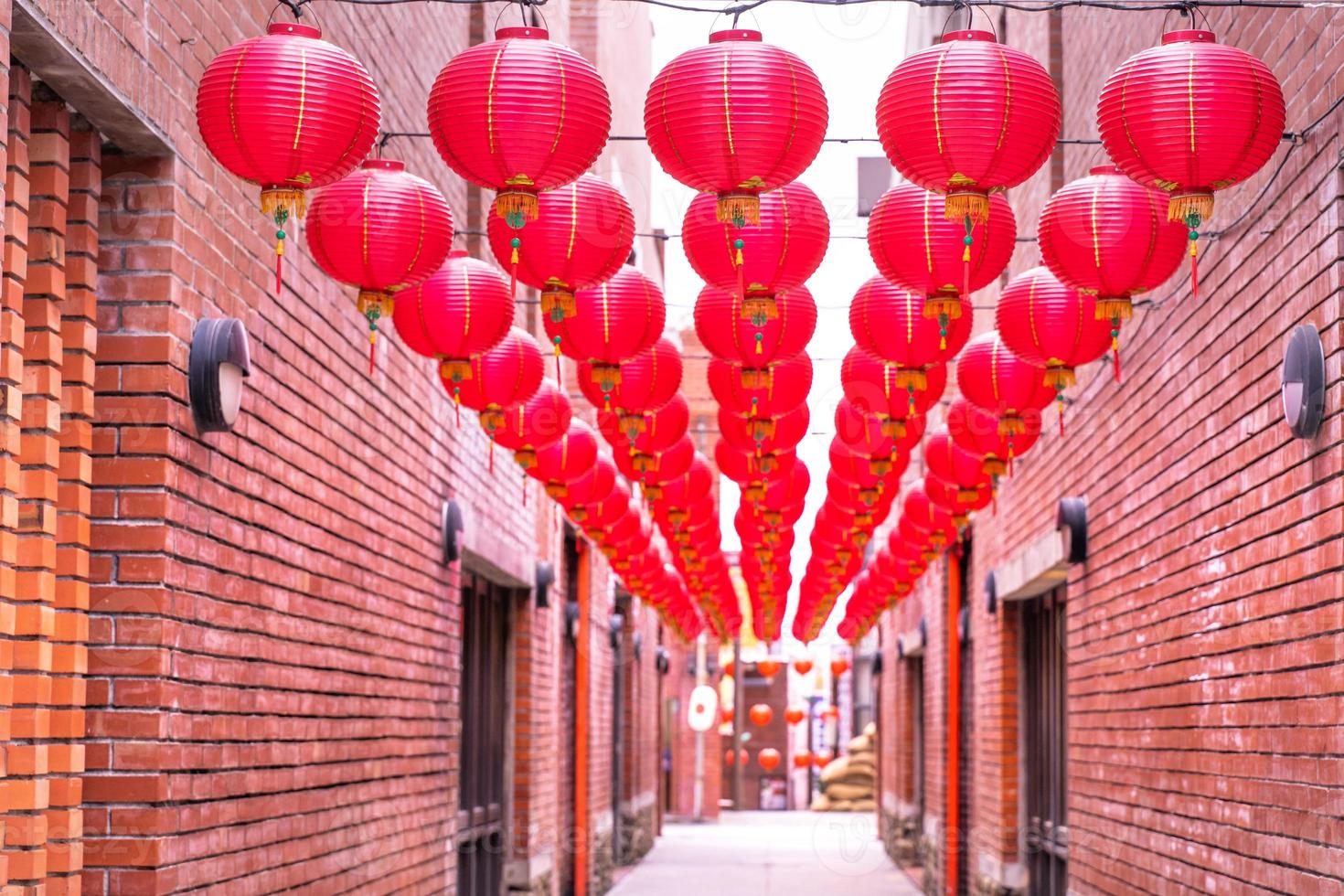 Beautiful round red lantern hanging on old traditional street, concept of Chinese lunar new year festival, close up. The undering word means blessing. photo