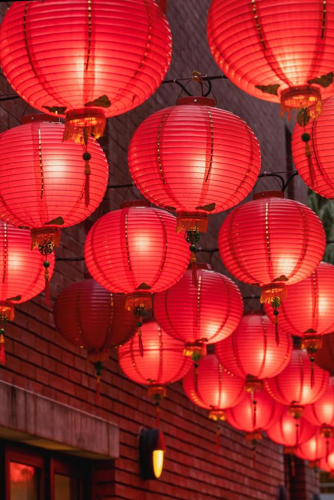 Beautiful round red lantern hanging on old traditional street, concept of Chinese lunar new year festival, close up. The undering word means blessing. photo