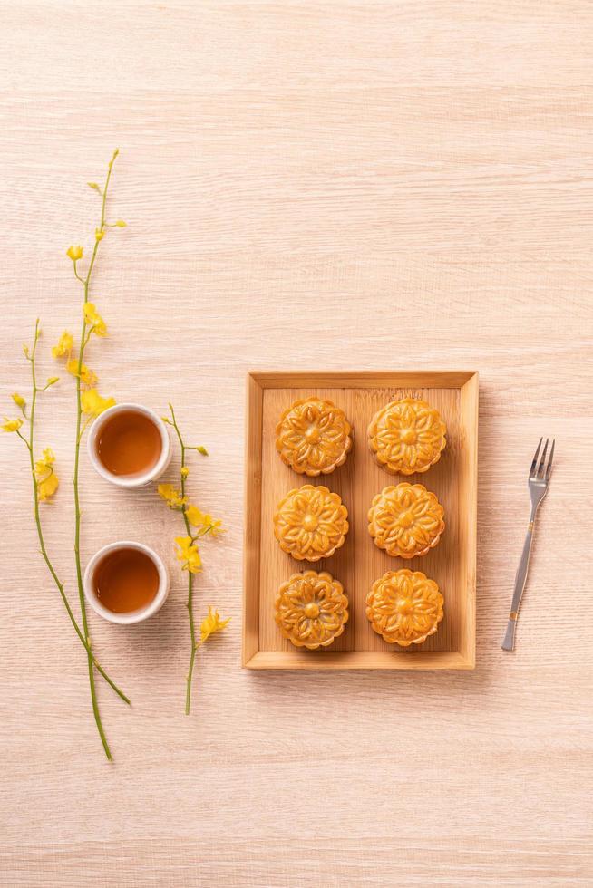 Mid-Autumn Festival holiday concept design of moon cake, mooncakes, tea set on bright wooden table with copy space, top view, flat lay, overhead shot photo