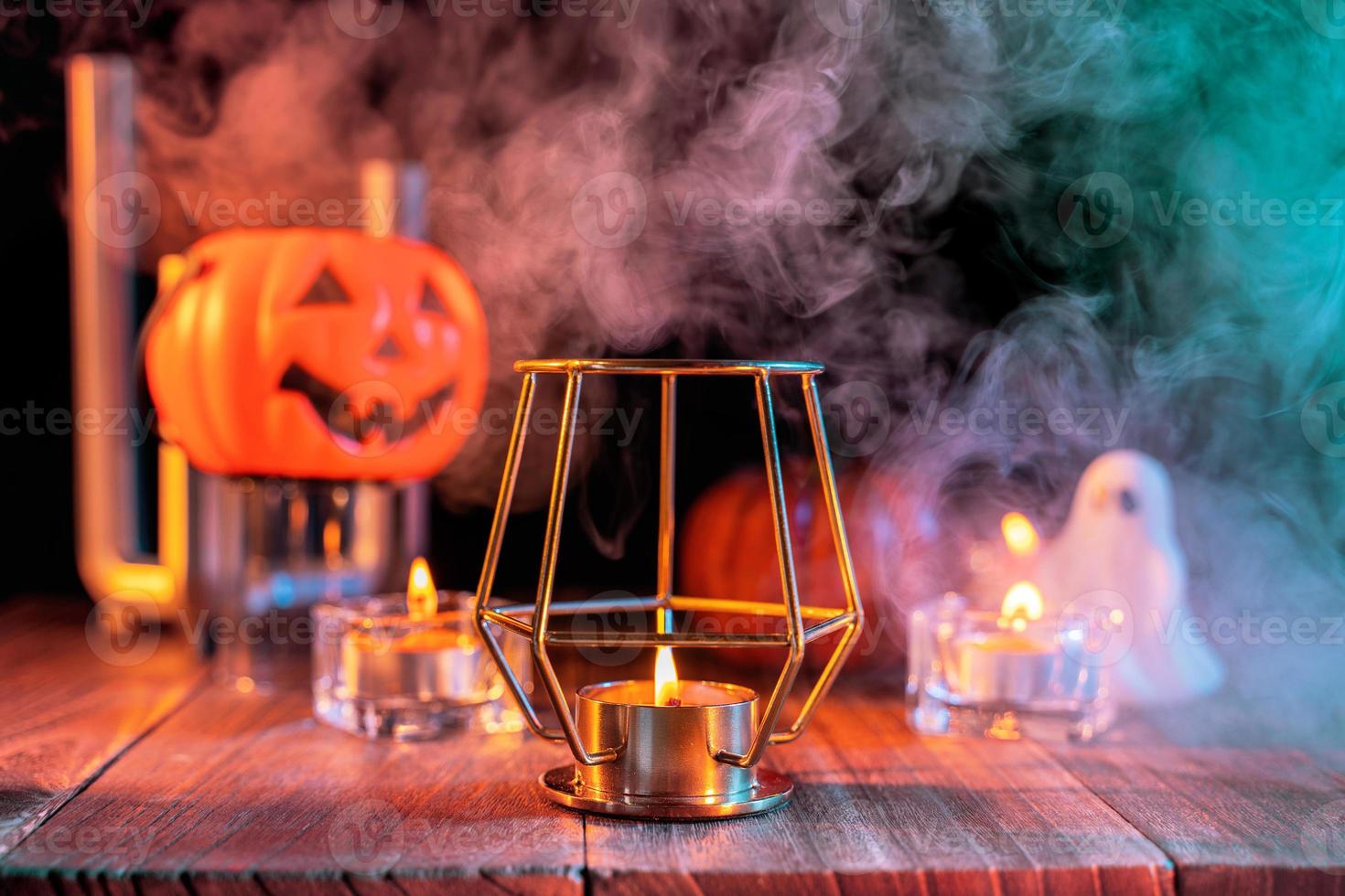 concepto de halloween, linterna de calabaza naranja y velas en una mesa de madera oscura con humo verde-naranja alrededor del fondo, truco o trato, cerrar foto