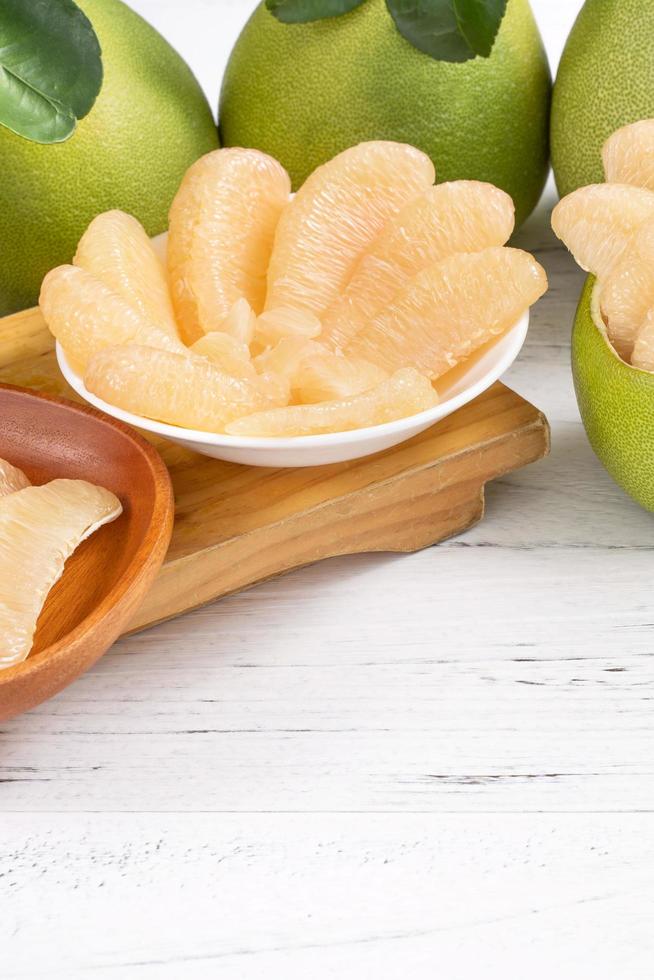 Fresh peeled pomelo, pummelo, grapefruit, shaddock on bright wooden table background. Seasonal fruit for Mid-Autumn Festival, close up, copy space. photo