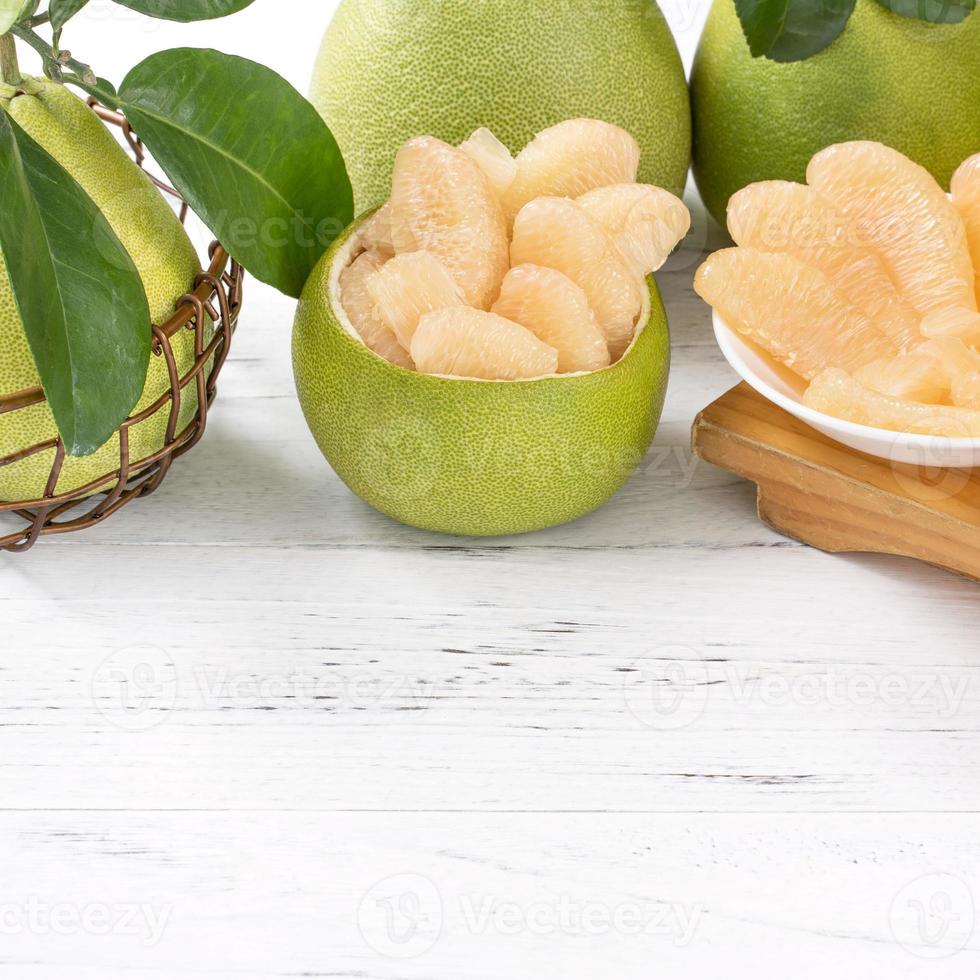 Fresh peeled pomelo, pummelo, grapefruit, shaddock on bright wooden table background. Seasonal fruit for Mid-Autumn Festival, close up, copy space. photo