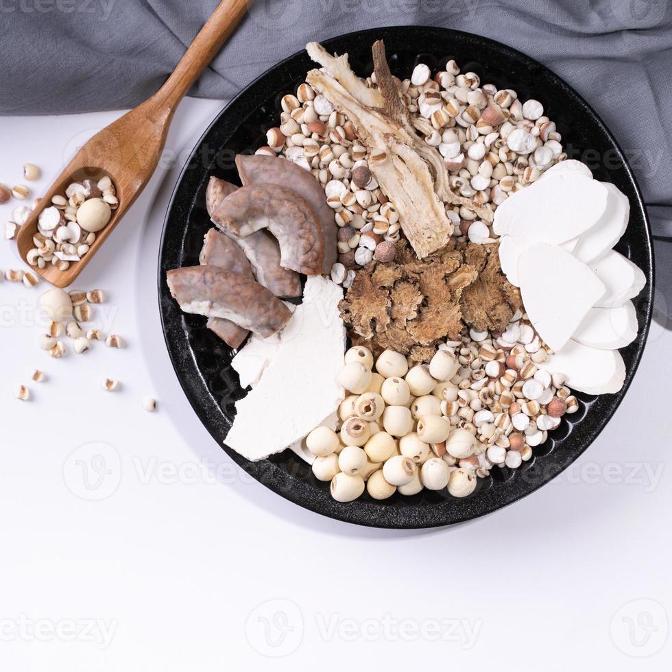 ingredientes de sopa de cuatro tónicos, sopa de cuatro sabores de hierbas. comida tradicional taiwanesa con lágrimas de trabajo, hierbas, intestinos de cerdo sobre fondo blanco foto