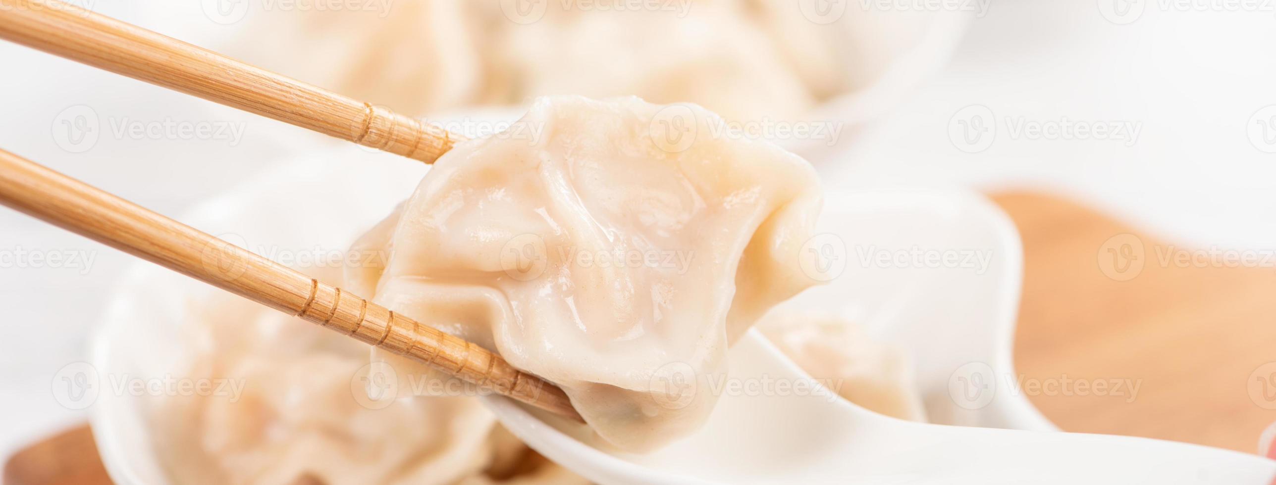 Fresh, delicious boiled pork, shrimp gyoza dumplings on white background with soy sauce and chopsticks, close up, lifestyle. Homemade design concept. photo