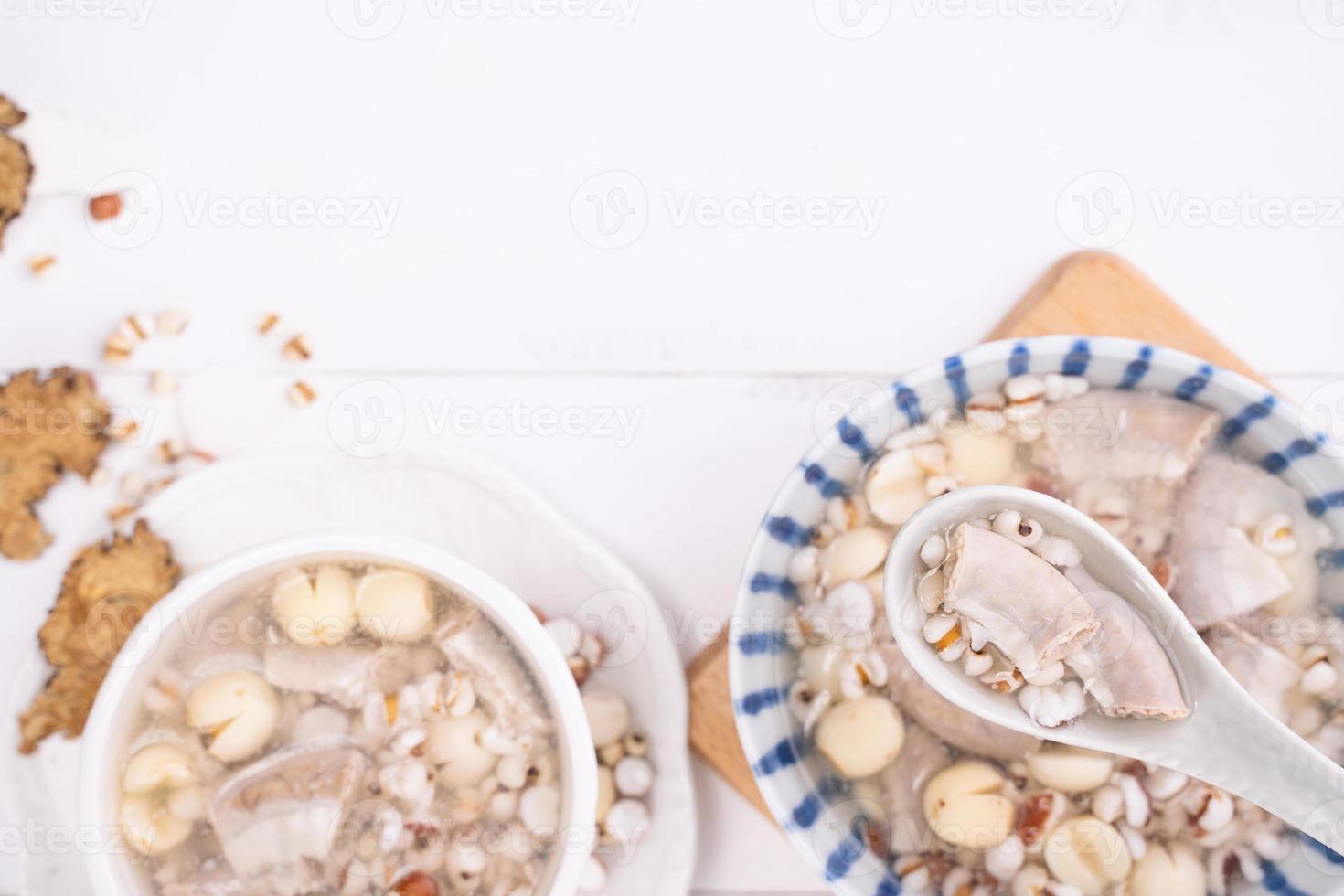 sabrosa sopa con sabor a hierbas de cuatro tónicos, comida tradicional taiwanesa con hierbas, intestinos de cerdo en una mesa de madera blanca, primer plano, puesta plana, vista superior foto