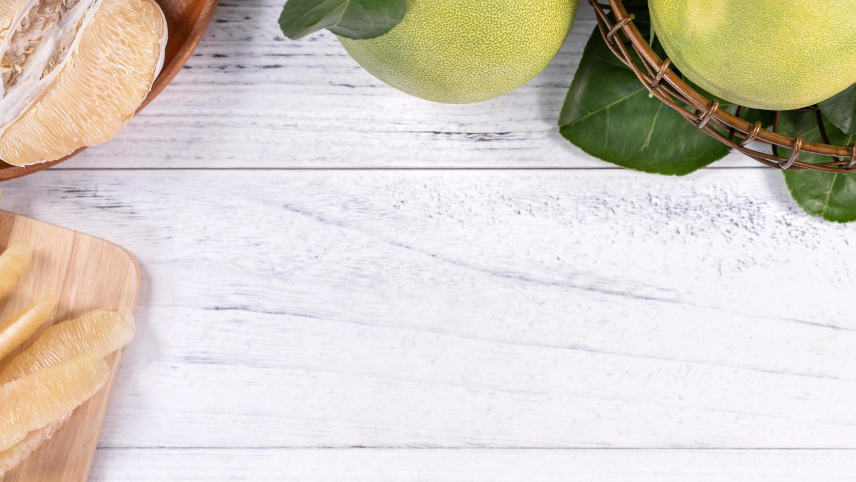 Fresh peeled pomelo, pummelo, grapefruit, shaddock on bright wooden background. Autumn seasonal fruit, top view, flat lay, tabletop shot. photo