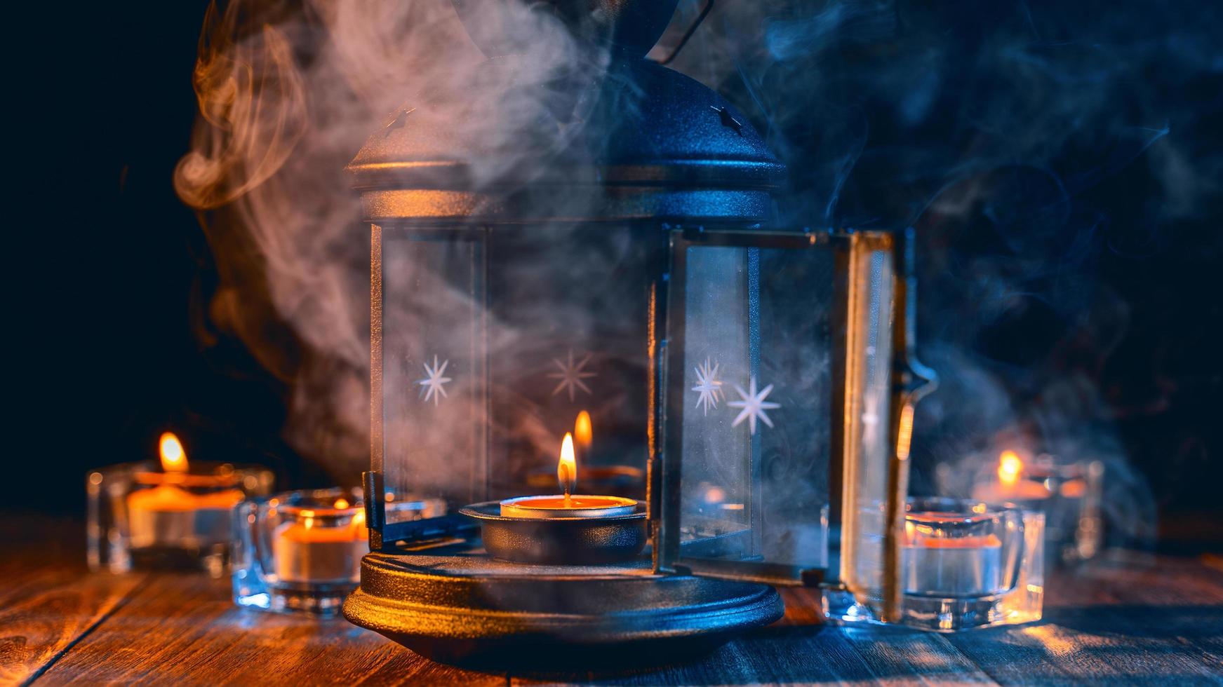 Halloween holiday concept design of pumpkin, candle, spooky decorations with green tone smoke around on a dark wooden table, close up shot. photo