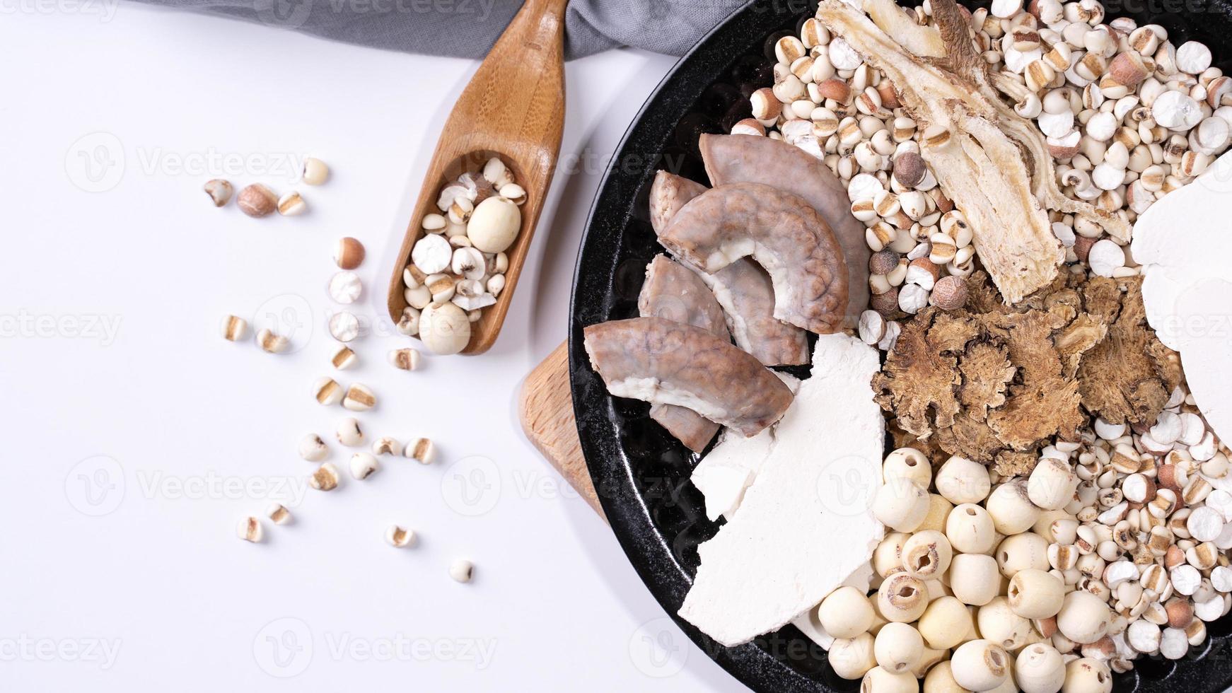 ingredientes de sopa de cuatro tónicos, sopa de cuatro sabores de hierbas. comida tradicional taiwanesa con lágrimas de trabajo, hierbas, intestinos de cerdo sobre fondo blanco foto