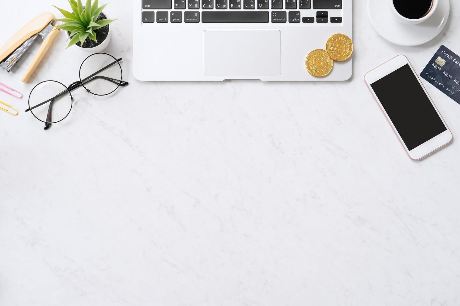 Concept of online payment with credit card with smart phone, laptop computer on office desk on clean bright marble table background, top view, flat lay photo