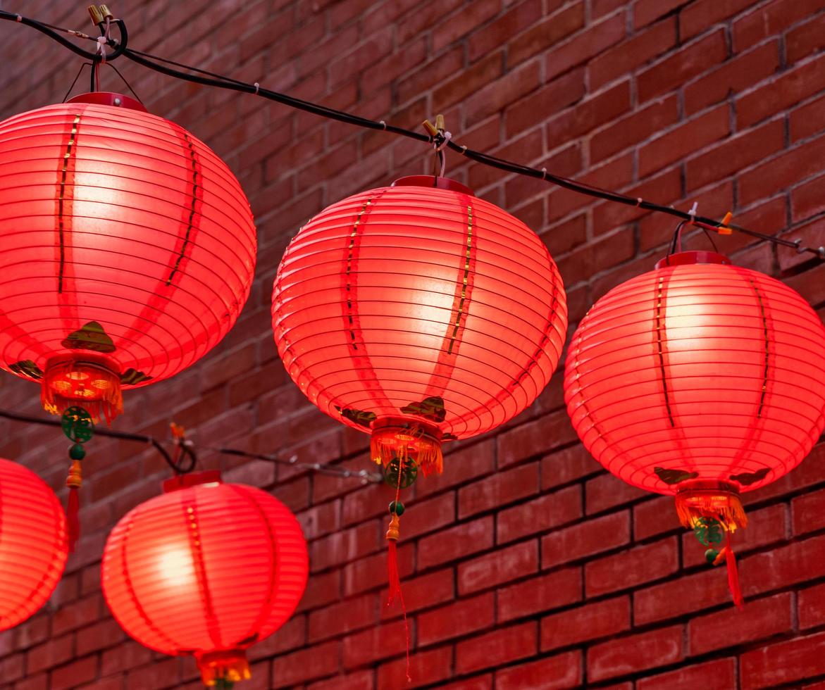 Beautiful round red lantern hanging on old traditional street, concept of Chinese lunar new year festival, close up. The undering word means blessing. photo