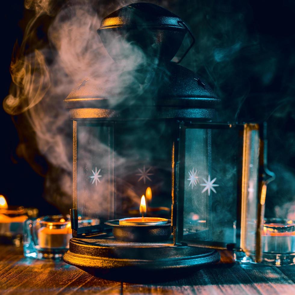 Halloween holiday concept design of pumpkin, candle, spooky decorations with green tone smoke around on a dark wooden table, close up shot. photo