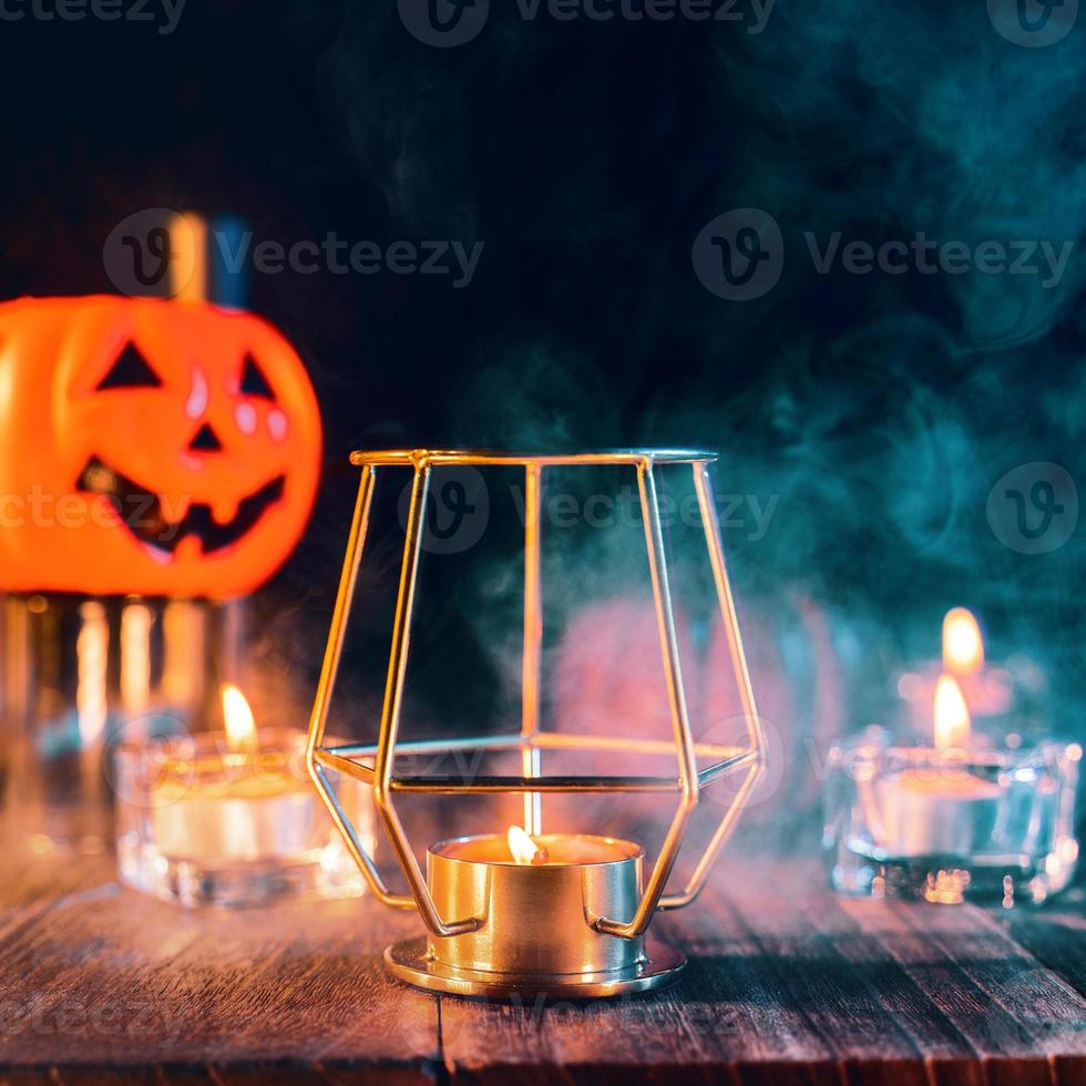 diseño de concepto de vacaciones de halloween de calabaza, velas, decoraciones espeluznantes con humo de tono verde alrededor de una mesa de madera oscura, primer plano. foto