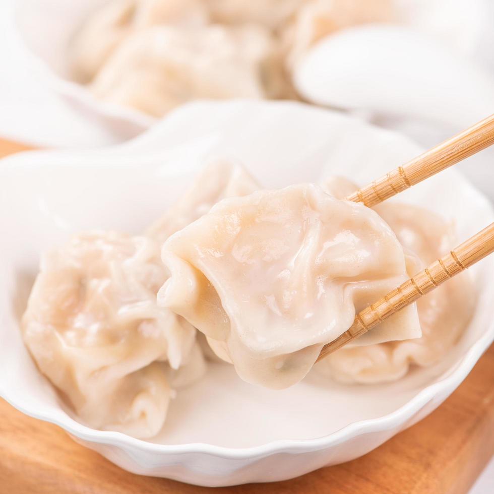 Fresh, delicious boiled pork, shrimp gyoza dumplings on white background with soy sauce and chopsticks, close up, lifestyle. Homemade design concept. photo