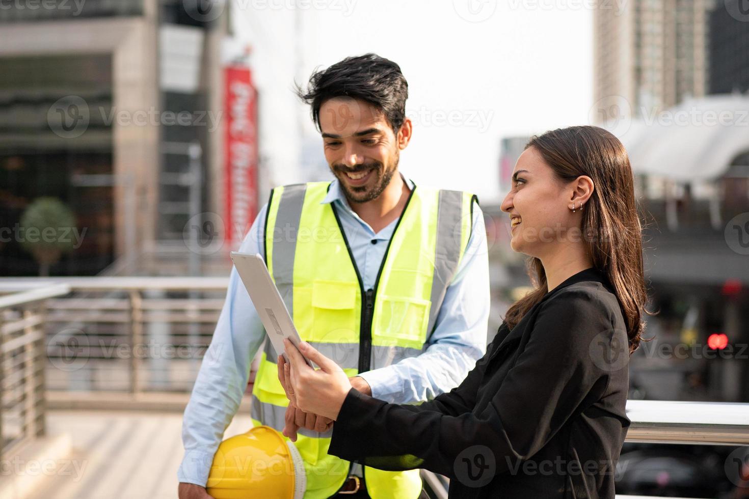 mujer de negocios y trabajador discutiendo con ingeniero en el sitio de construcción. foto