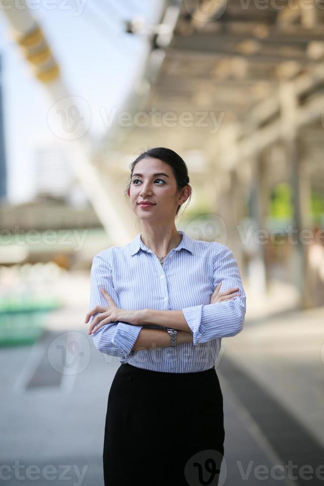 Portrait of young beautiful business woman at outside. Crossed arms photo