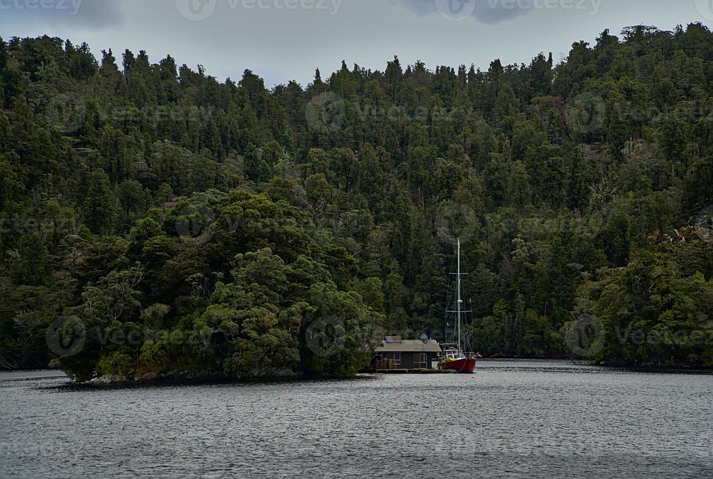 casa flotante en medio del lago rodeada de árboles foto