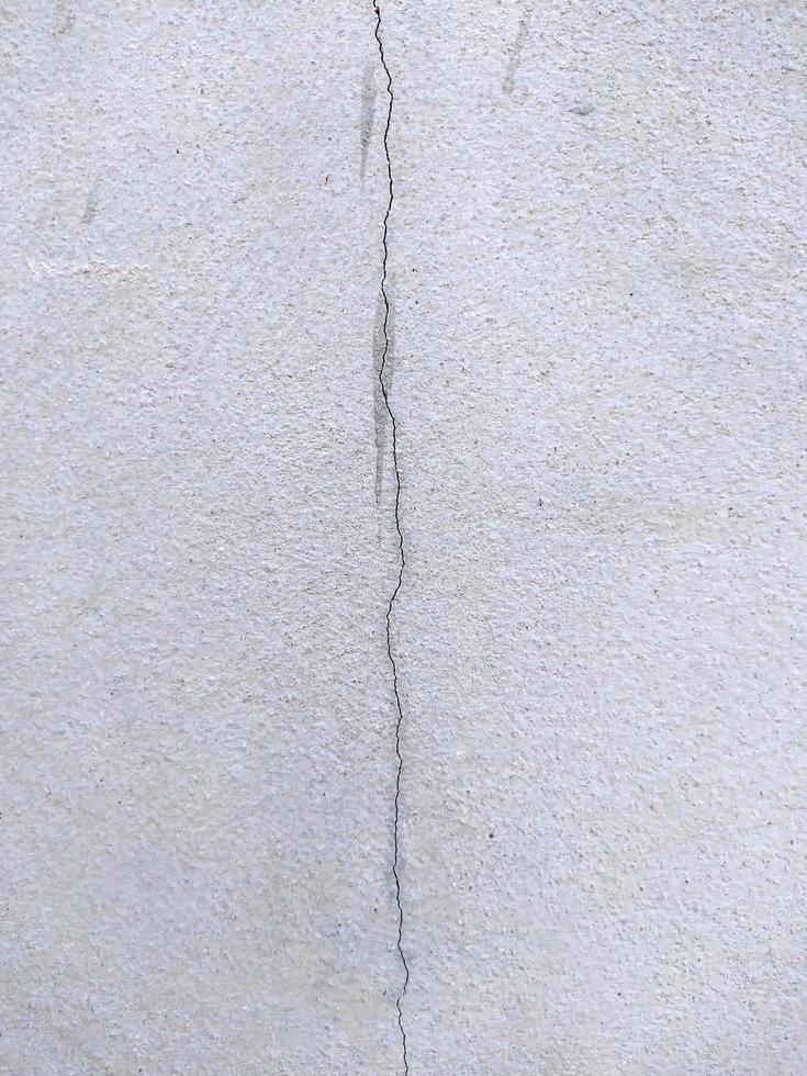 A long crack in a cement wall in a building. photo