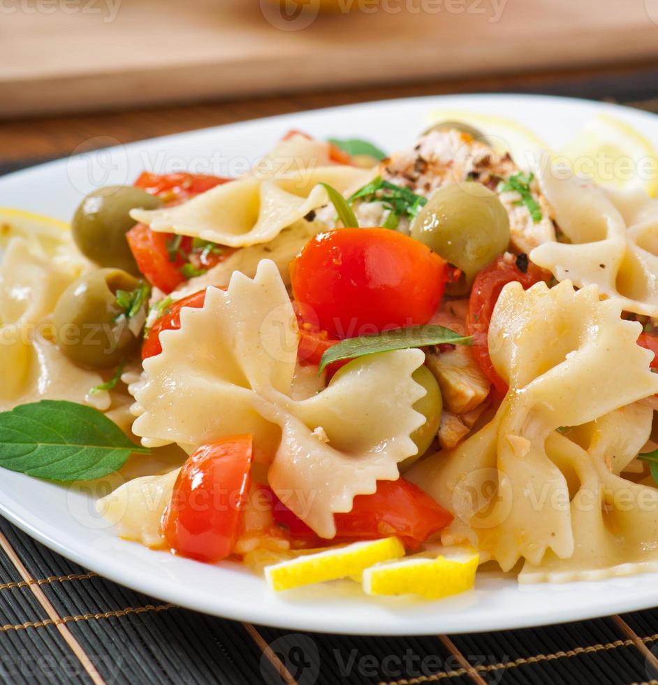 ensalada española con arcos de pasta, tomates y pollo foto