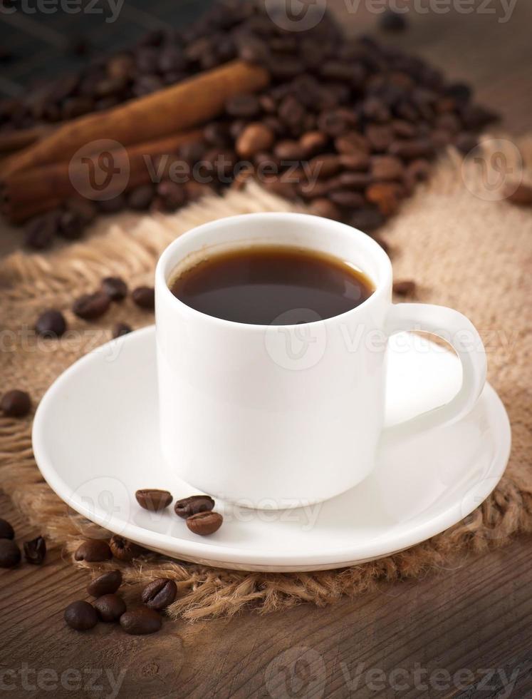 closeup view of a cup of coffee, brown sugar and coffee beans photo