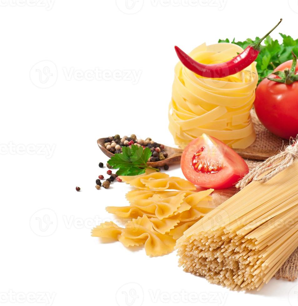 espaguetis de pasta, verduras, especias aisladas en blanco foto