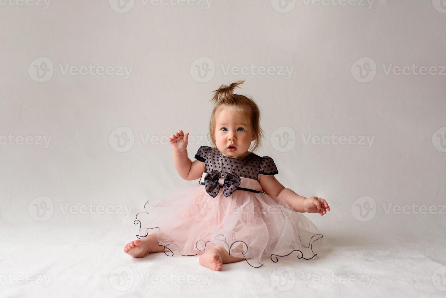 Little girl 6 months old with a comb in hand on a white background. photo