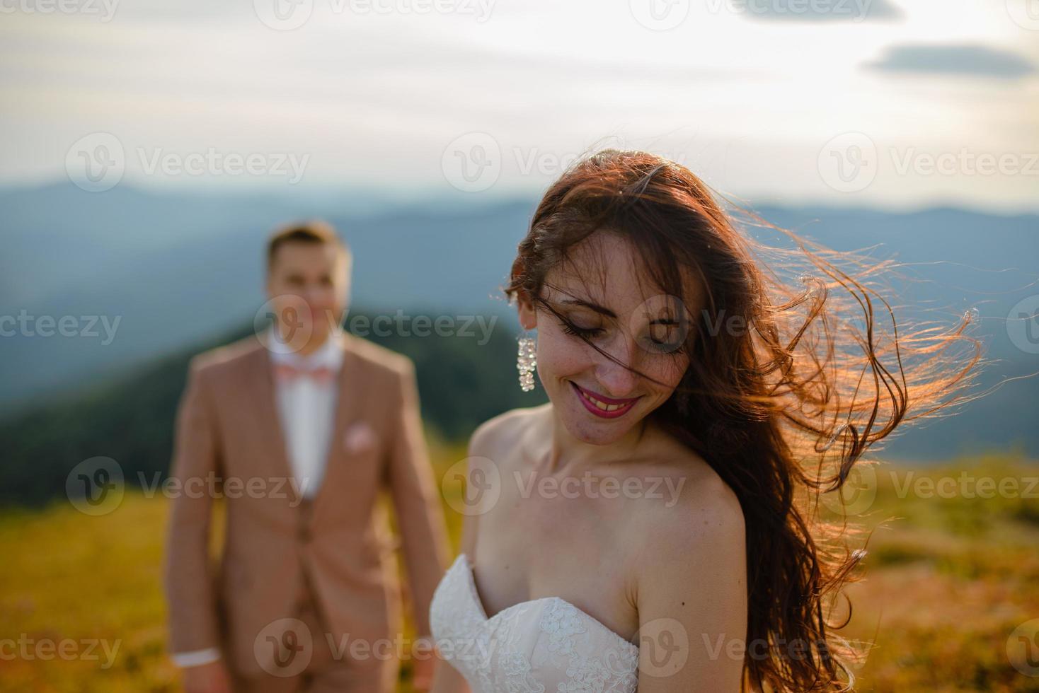 Wedding couple in love kissing and hugging near rocks on beautiful landscape photo