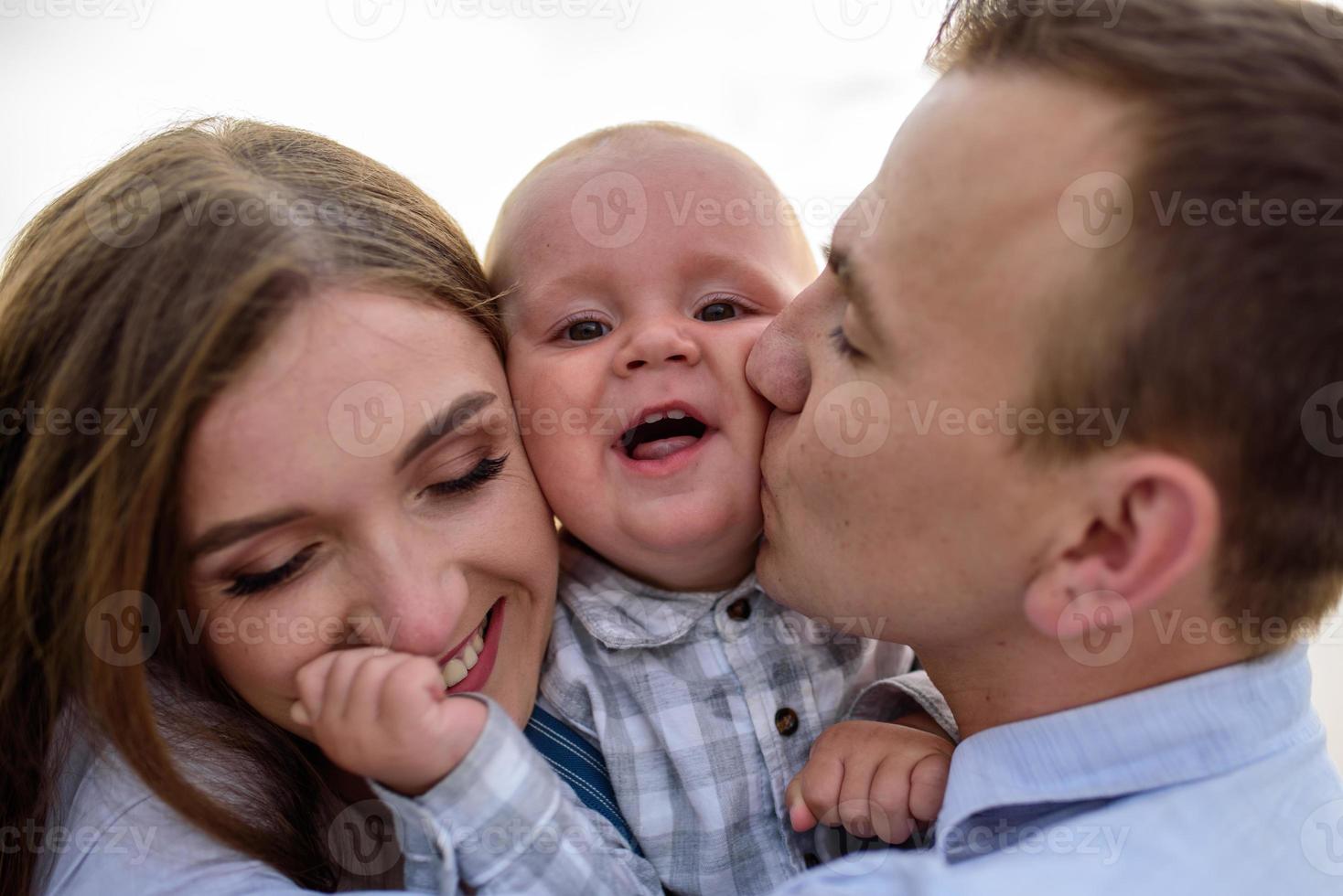 Father and mother lead their one-year-old son by the hand. photo