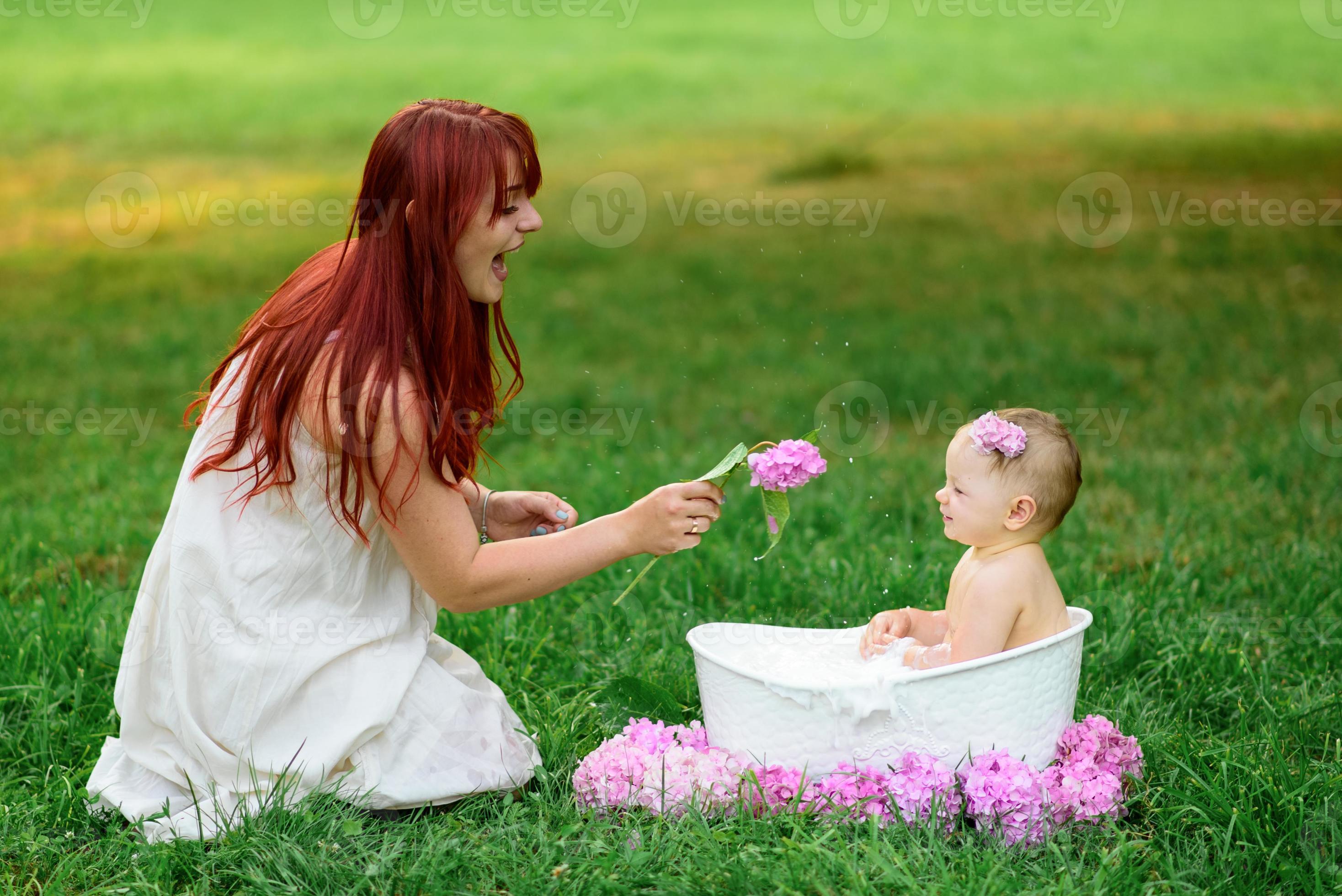 Mom helps her little oneyearold daughter bathe in the bathroom