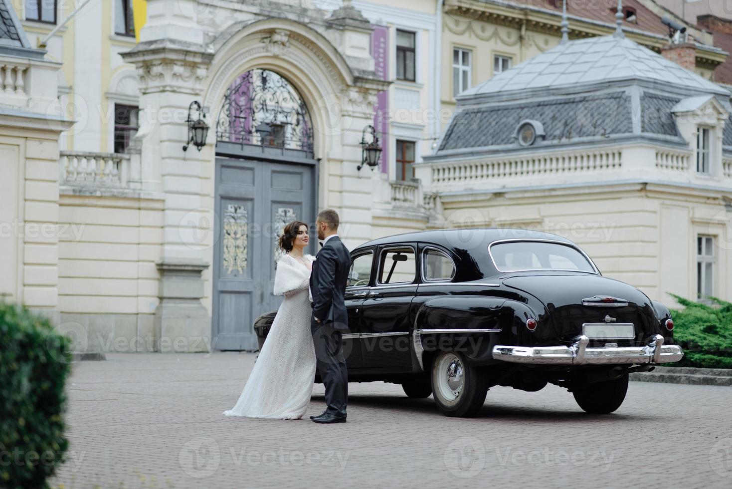 Beautiful retro couple against vintage car photo