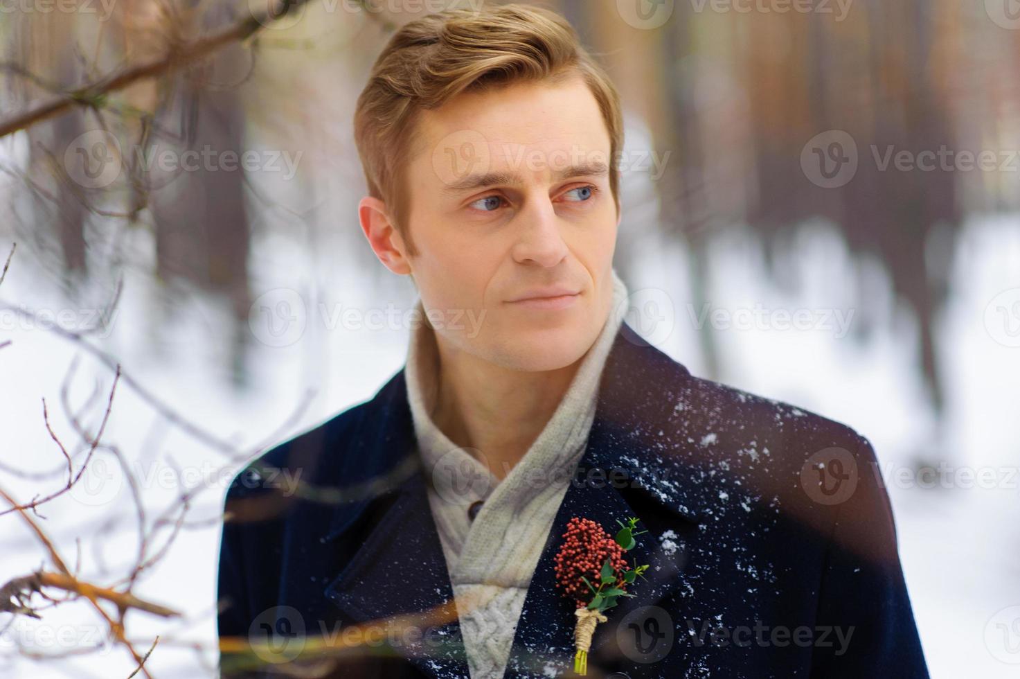 apuesto joven novio en el bosque de invierno foto