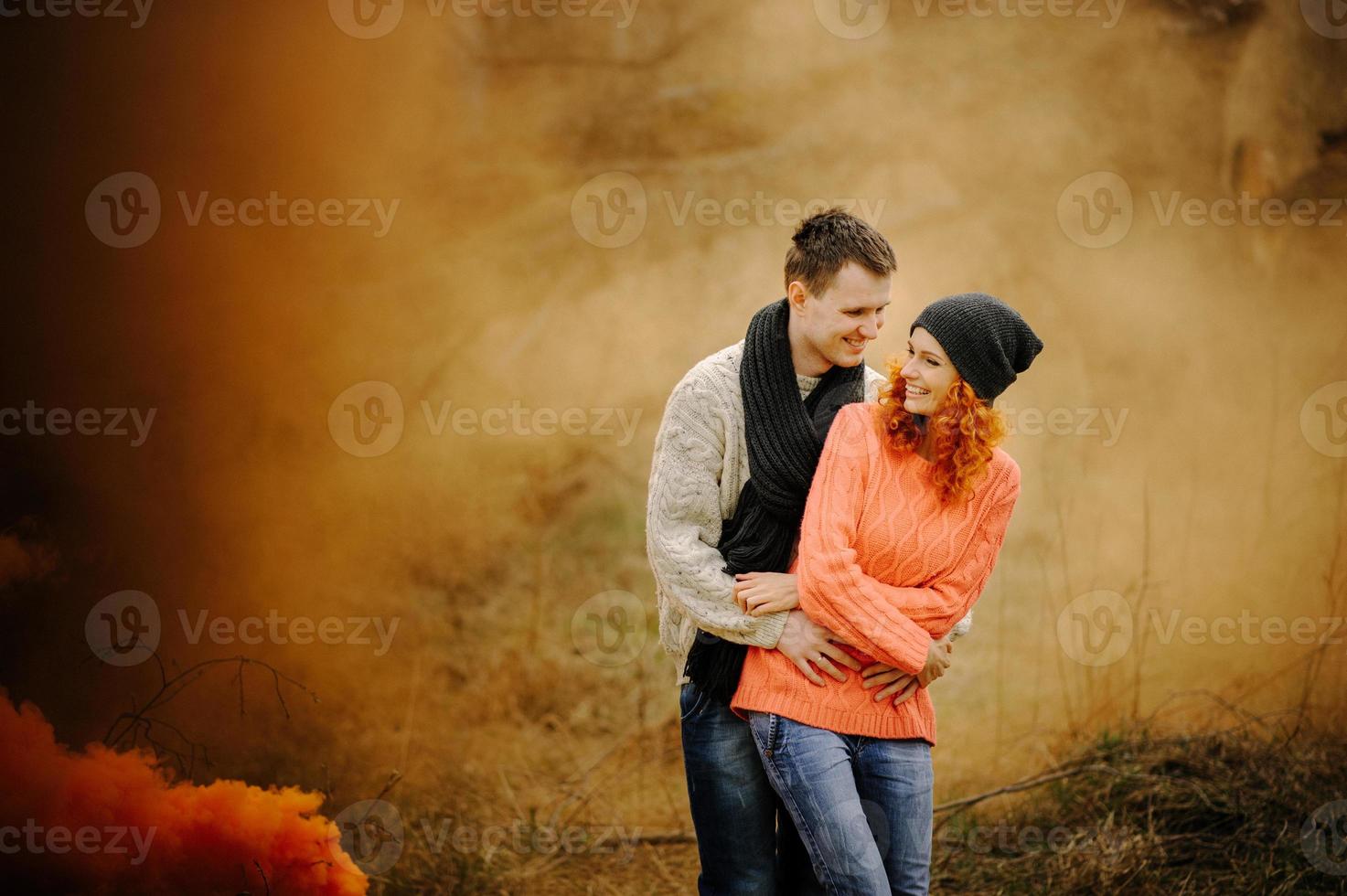 Young happy couple holding smoke bombs on camping photo