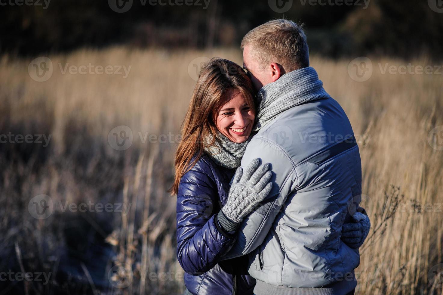 retrato de una pareja joven enamorada de un oso de peluche en el bosque invernal foto