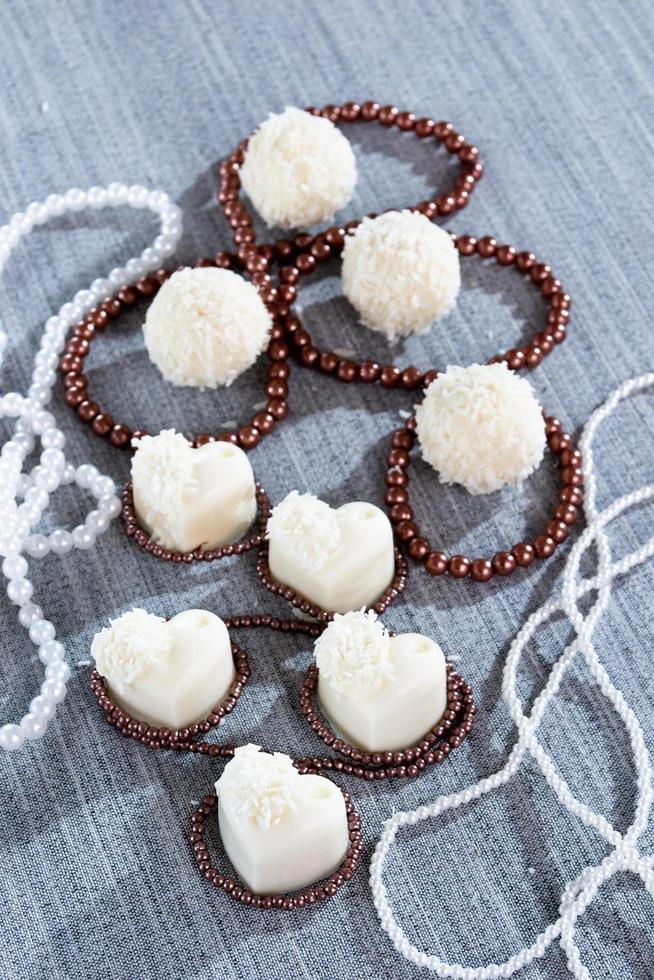 heart-shaped chocolates with candies in coconut flakes of beads photo