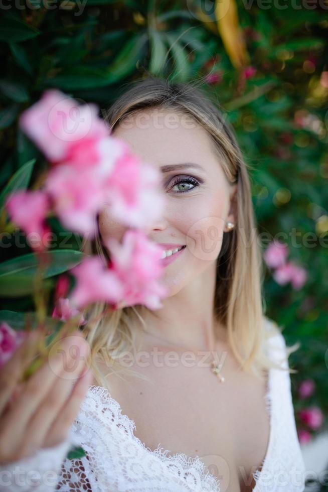 chica hermosa modelo, con flores de peonía cerca de la cara. cosmética, belleza, maquillaje, boda y cosmetología. foto
