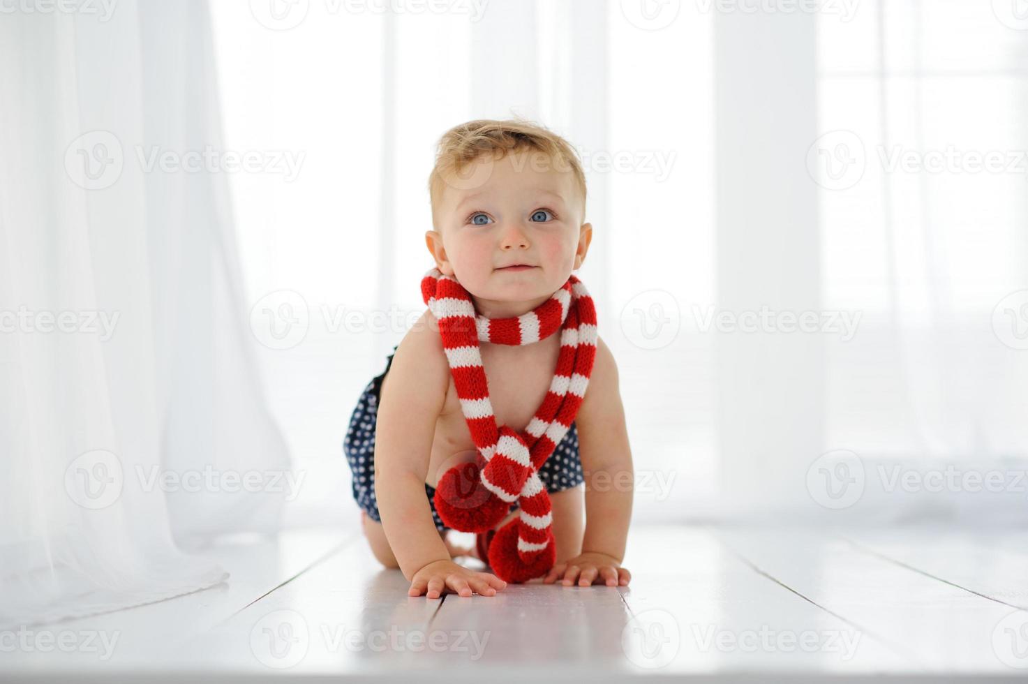 The little one-year-old girl smiles and sits. photo