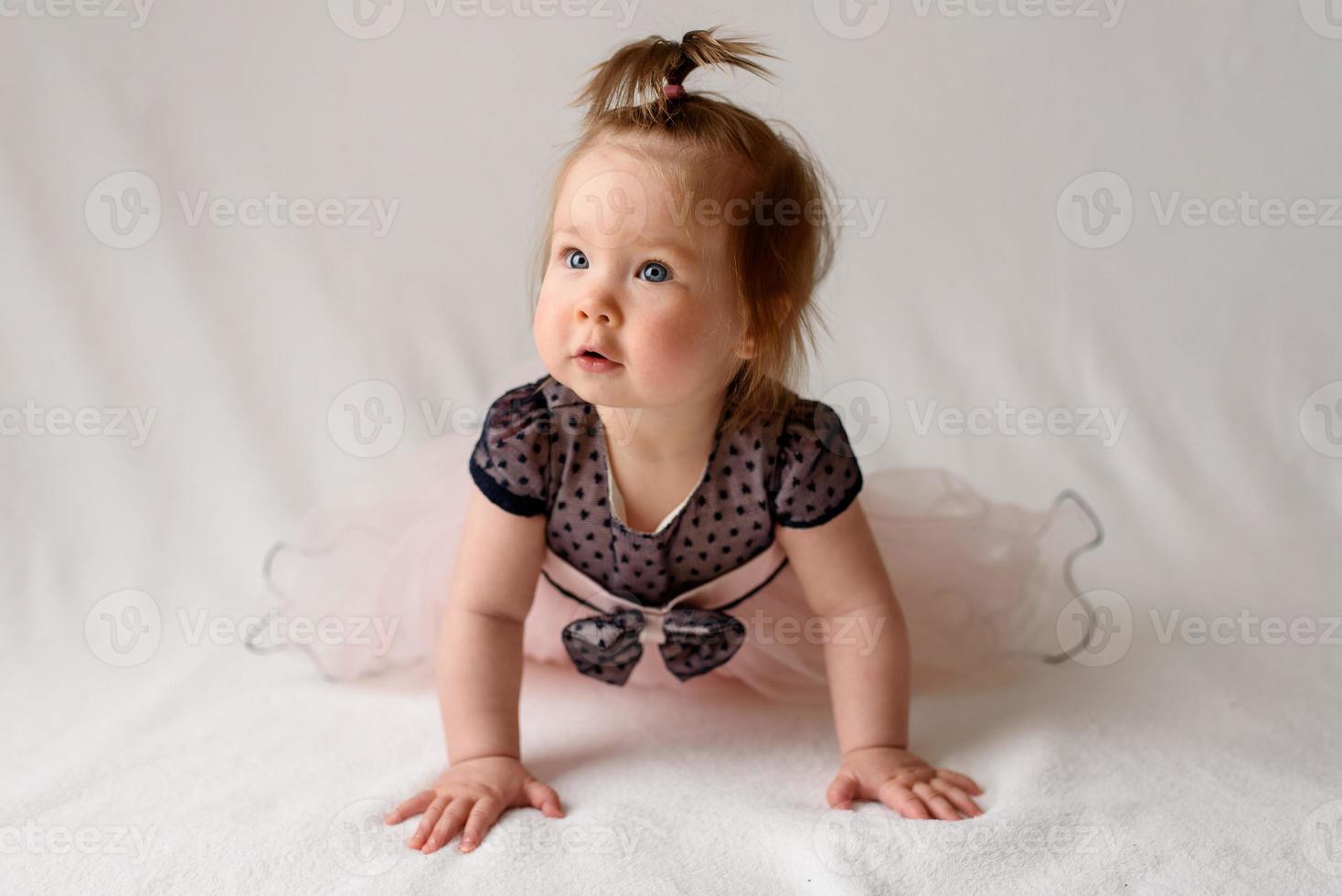 niña de 6 meses con un peine en la mano sobre un fondo blanco. foto