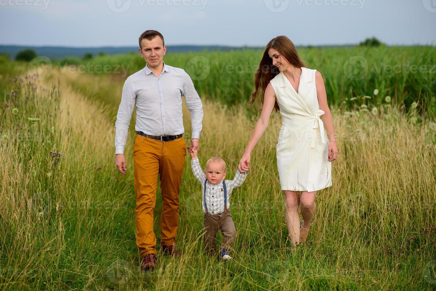 padre y madre llevan de la mano a su hijo de un año. foto