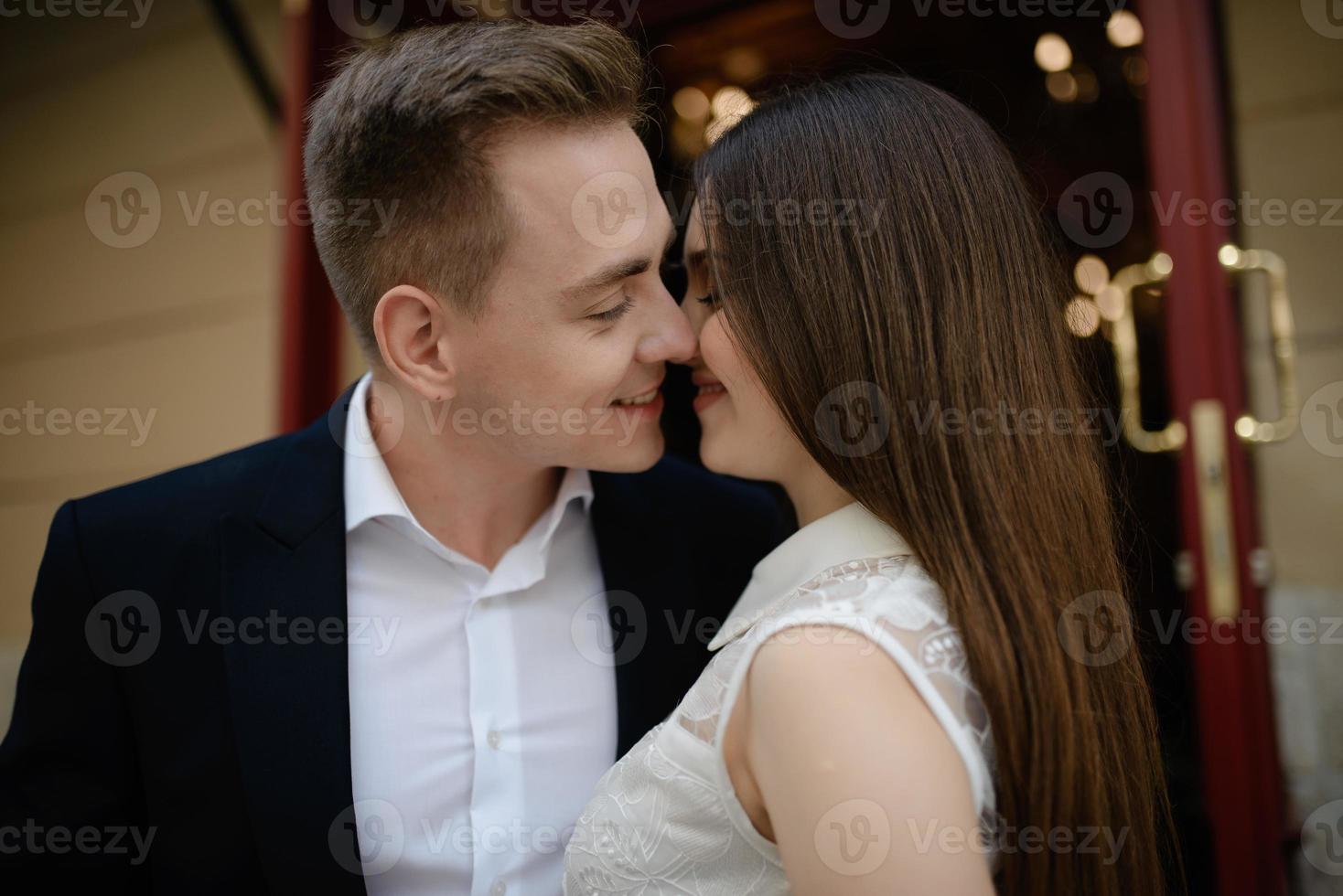 feliz pareja casada está en una luna de miel, tomando un brunch en un agradable café con un interior moderno, terraza de verano con plantas verdes y agradables foto