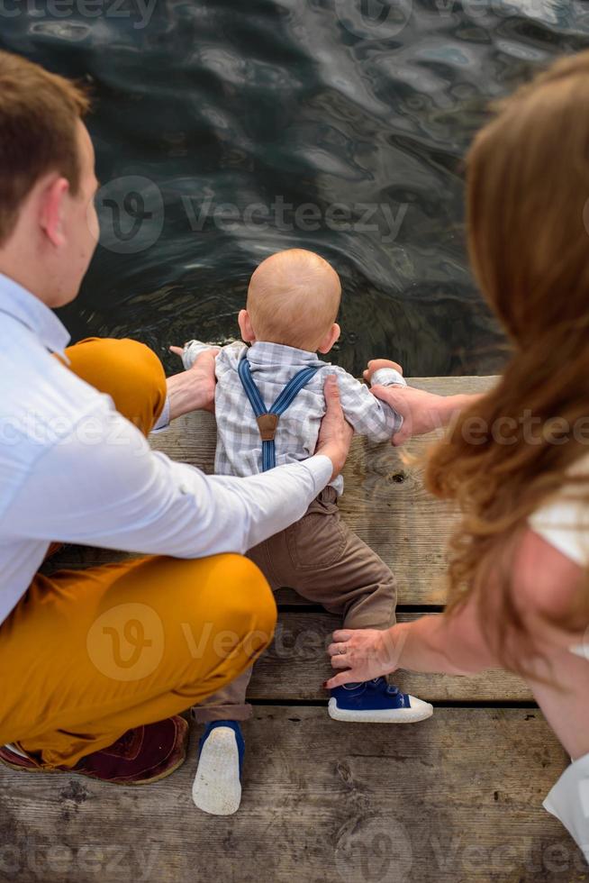 Father and mother lead their one-year-old son by the hand. photo